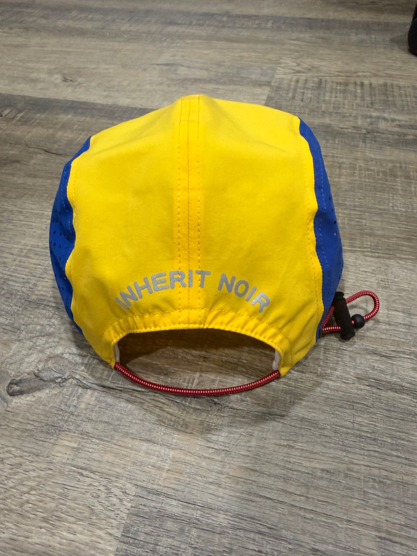 Inherit Noir "Consistency Wins" Running Cap. Flat-lay product detail.