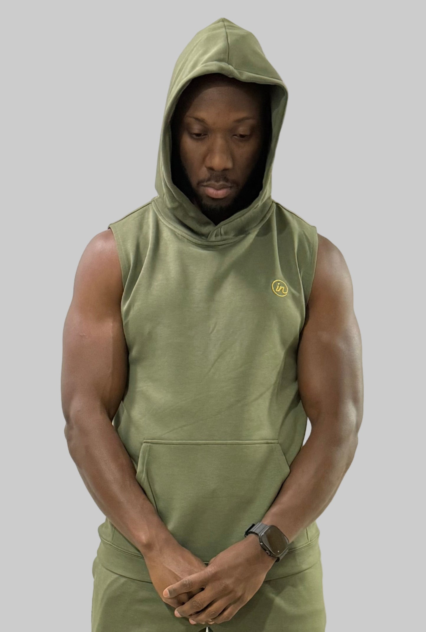 Inherit Noir IN Sleeveless Hoodie in Olive. Flat-lay product detail.