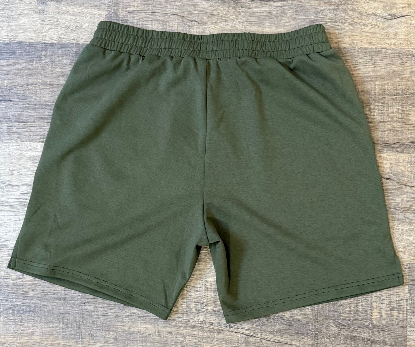 Green shorts on a wooden floor