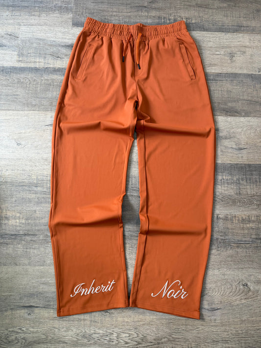 Inherit Noir Relaxed Fit Signature Joggers in Orange. Flat-lay product detail.