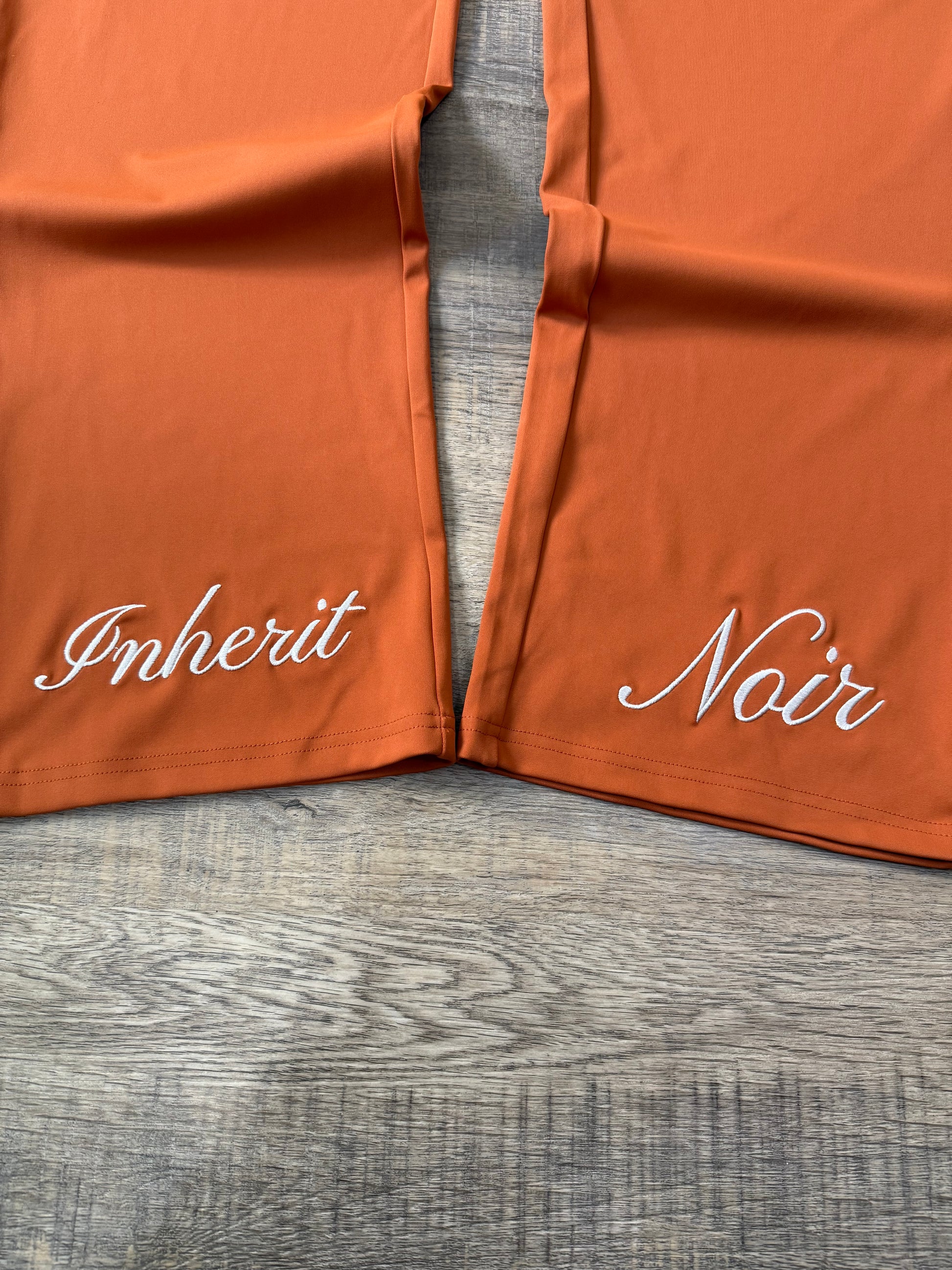 Inherit Noir Relaxed Fit Signature Joggers in Orange. Flat-lay product detail.