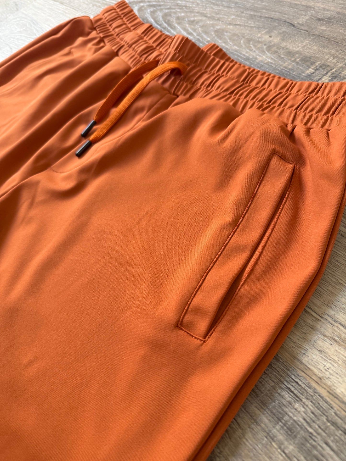 Inherit Noir Relaxed Fit Signature Joggers in Orange. Flat-lay product detail.