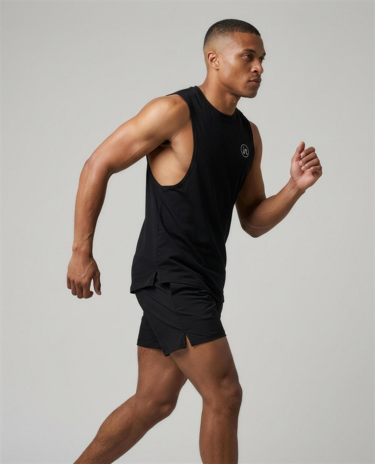 IN Motion Tank Black — studio 3/4 action on-model